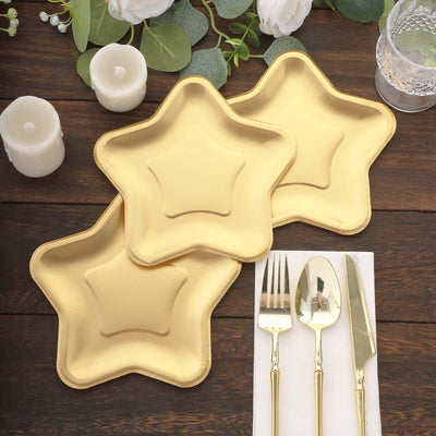 Golden star-shaped plates set on a rustic wooden table with cutlery and candles.