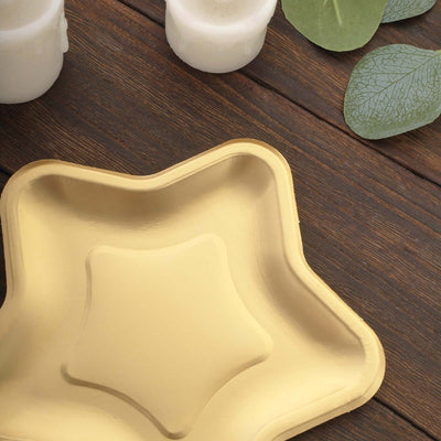 Star-shaped golden tray on a wooden surface with candles and leaves.