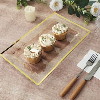 Three decorated cupcakes on a decorative platter with utensils and floral accents.