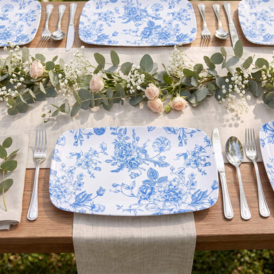 Elegant blue floral dinnerware with eucalyptus and rose table centerpiece outdoors