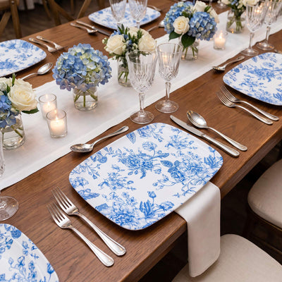 Blue floral dinnerware set on a wooden table with elegant floral centerpieces