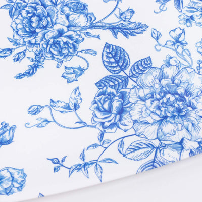 Blue floral toile pattern on white porcelain plate close-up