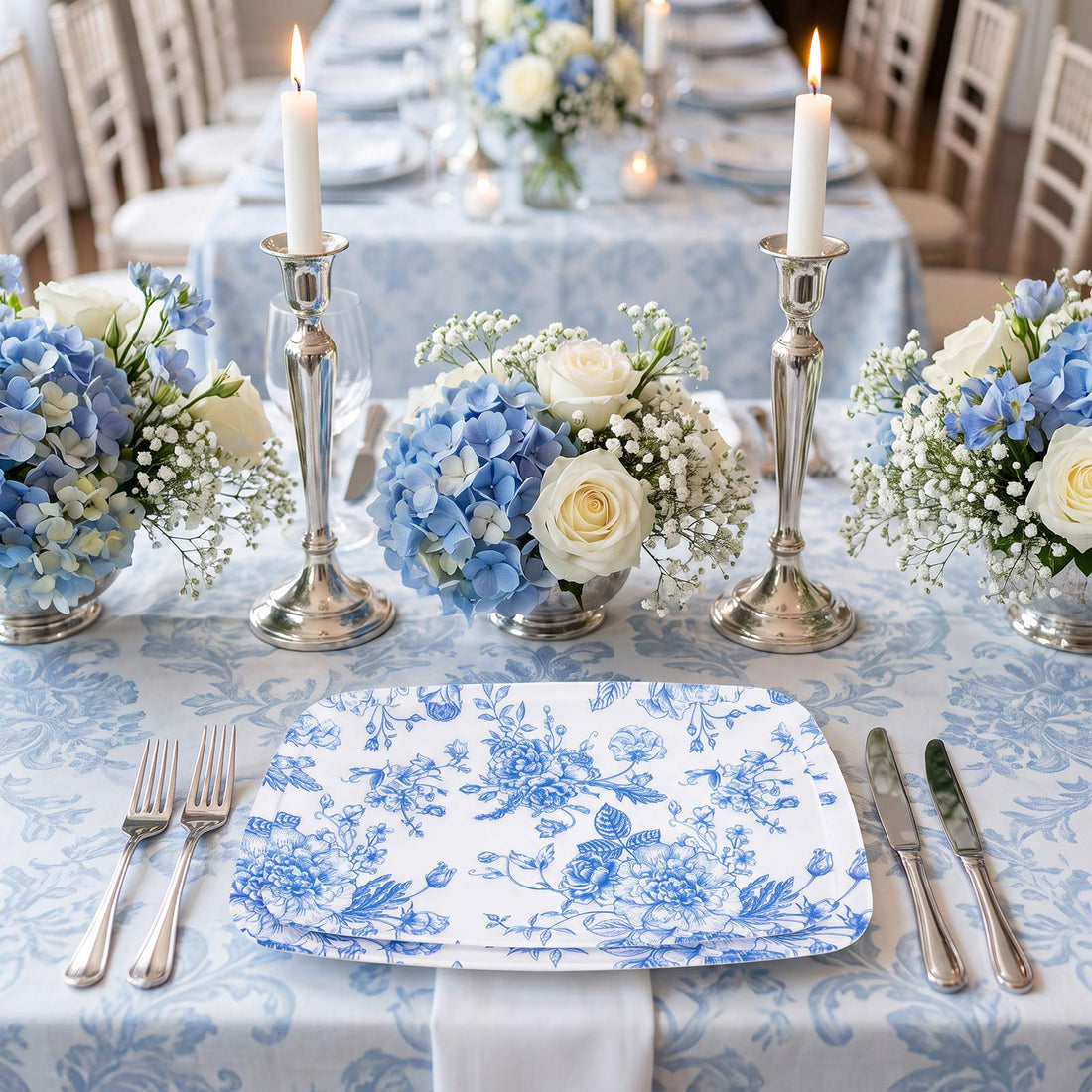 Elegant blue and white floral table setting with candles and centerpieces