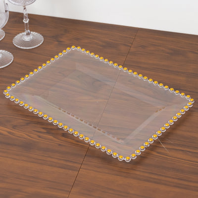 Clear serving tray with decorative golden beads around the edge.