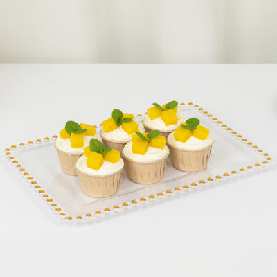 Delicious mango cupcakes with mint leaves on a decorative platter.