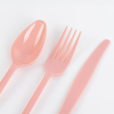 Pink plastic cutlery set including spoon, fork, and knife.