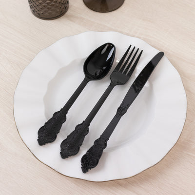 Black ornate cutlery set on a white plate
