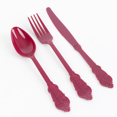 Red plastic cutlery set including a spoon, fork, and knife on a white background.