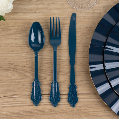 Blue plastic cutlery set with ornate handles on wooden surface.