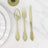 Green plastic cutlery set including spoon, fork, and knife on marble background.