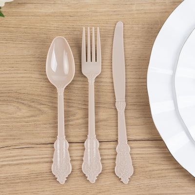 Elegant beige plastic cutlery set: spoon, fork, and knife on a wooden table.