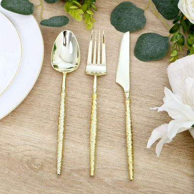 Gold hammered flatware set with spoon, fork and knife on elegant table setting