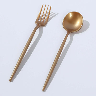 Gold cutlery set including a fork and spoon on a plain background