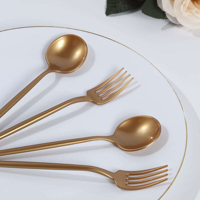 Gold cutlery set featuring forks and spoons on a white plate.