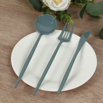 Blue plastic cutlery set on a white plate with floral backdrop.