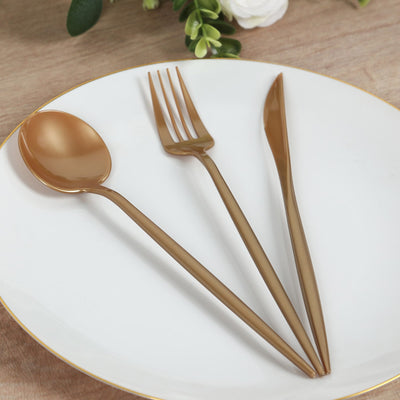 Gold plastic cutlery set on a white plate.