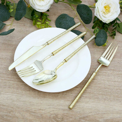 Gold flatware set with white plate and floral table decor