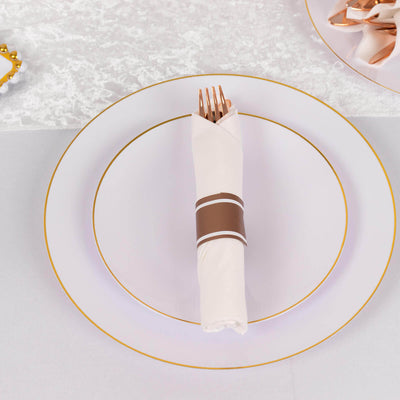 Elegant white plate set with a neatly folded napkin and gold-accented cutlery.