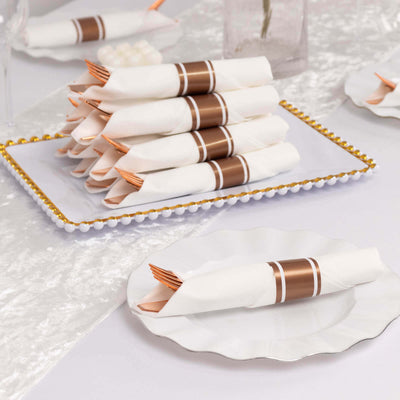 Elegant napkin rolls with copper bands, styled on a decorative plate.