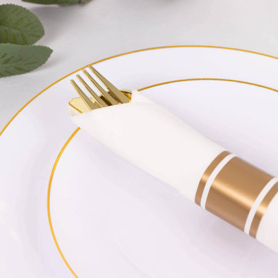 Elegant gold fork wrapped in a white napkin on a stylish plate.