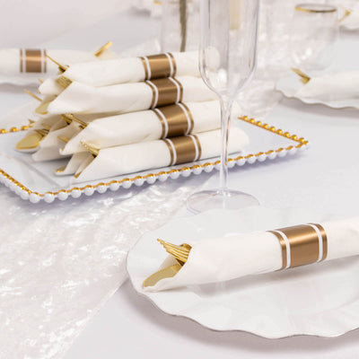 Elegant white napkins with gold accents on a decorative table setting.