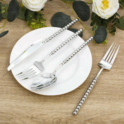 Elegant silver beaded flatware set with plate and floral table decor