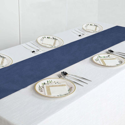 Navy table runner on a white table with decorative plates and cutlery.