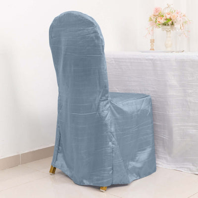 Gray chair cover draped over a chair in a dining setting.