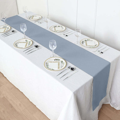 Elegant light blue table runner on a white table setting with plates and glasses.