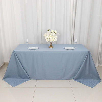 Blue tablecloth draped elegantly on a table with floral centerpiece and glassware.