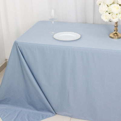 Elegant blue tablecloth draped over a table with a plate and glass.