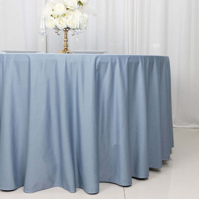 Blue tablecloth draped elegantly over a round table with floral centerpiece.