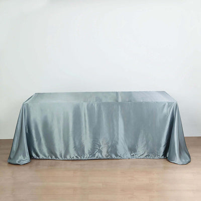 Gray satin tablecloth draped over a table on a plain background