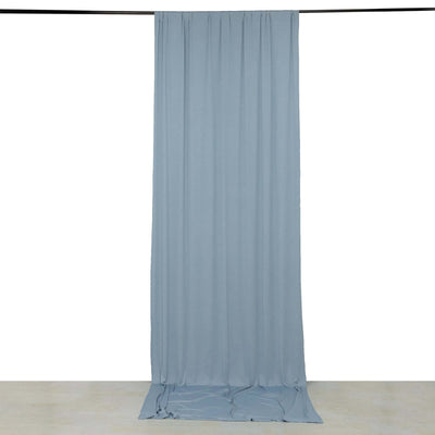 Light blue fabric drape hanging from a rod on a plain backdrop