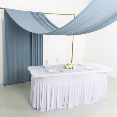 Elegant table setting with draped fabric backdrop for events.