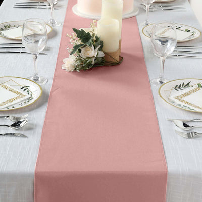 Pink table runner on a beautifully set dining table with candles and floral decor.