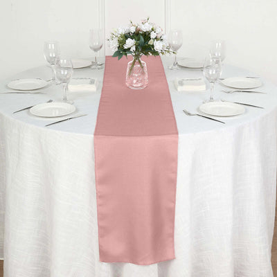 Pink table runner on a round dining table set with plates and glassware.