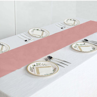 Elegant pink table runner on a white table setting with decorative plates and cutlery.