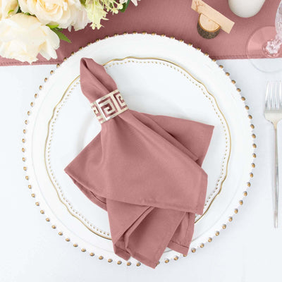 Elegant pink napkin on a decorative plate set for dining.
