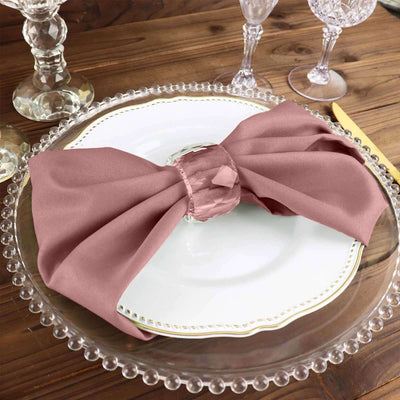 Elegant mauve napkin tied with a ring on a decorative plate setting.