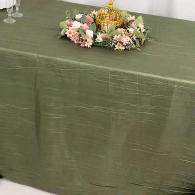 Olive green tablecloth with floral centerpiece arrangement.