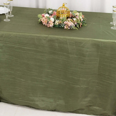 Green tablecloth with floral centerpiece and elegant decor.