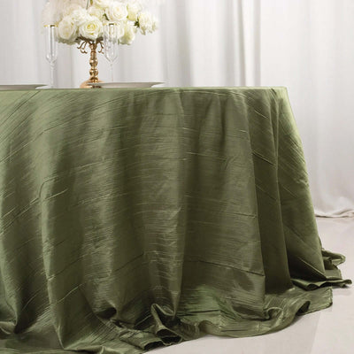 Elegant olive green tablecloth draping over a table with floral centerpiece.