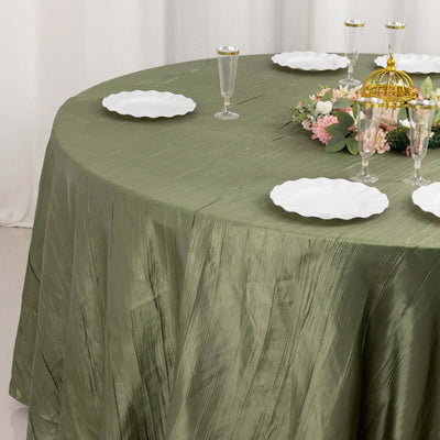 Olive green tablecloth with decorative plates and floral centerpiece