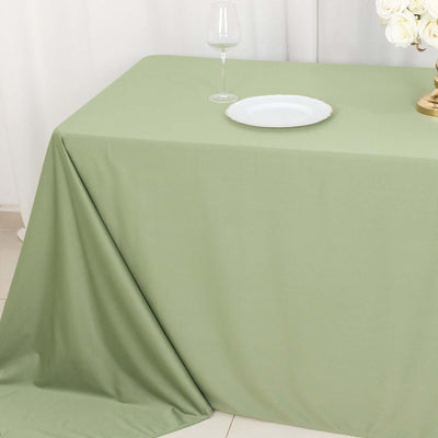 Green tablecloth draped elegantly on a table with a plate and glass.