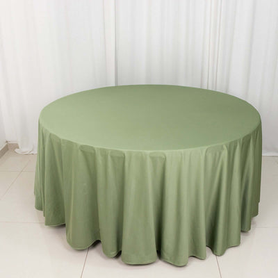 Round olive green tablecloth on a white backdrop