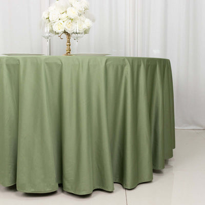 Green tablecloth draped elegantly over a round table with white floral decor.