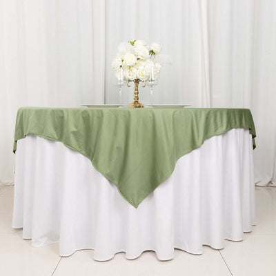 Elegant green tablecloth draped over a white table with floral centerpiece.