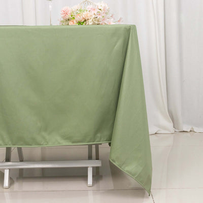 Green tablecloth draped over a table with floral arrangement