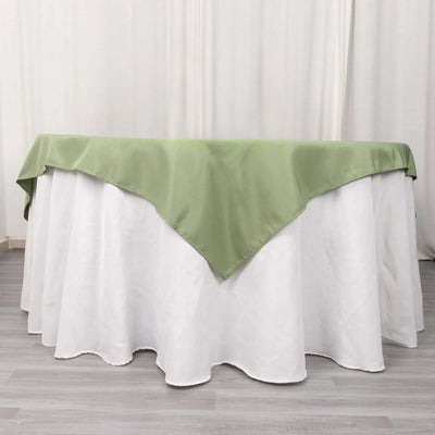 Green table cover draped over a white tablecloth in a studio setting.
